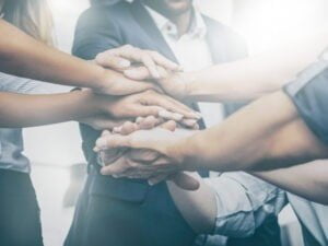 Close up view of young business people putting their hands together. Stack of hands. Unity and teamwork concept.